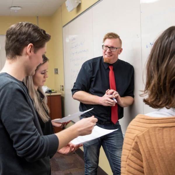 Andrew Lotz engages with students at the whiteboard in class