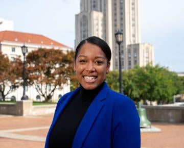 Bianca DeJesus standing outside in front of the cathedral of learning