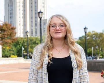Rachel Clites standing outside in front of the cathedral of learning