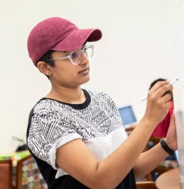 Woman in a hat erasing a whiteboard