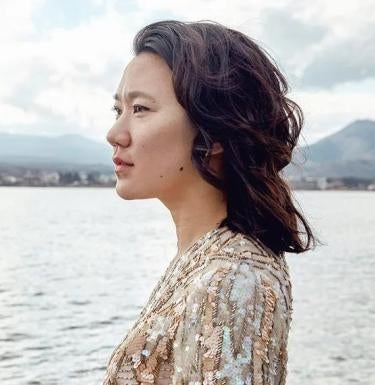 Diana Khoi Nguyen stands at the shore line of a lake