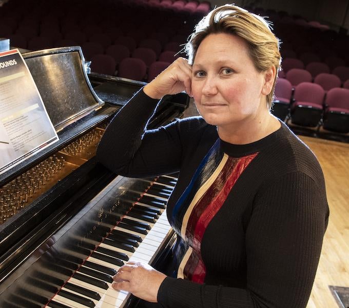 Adriana Helbig, woman with blonde hair seated at a piano on stage