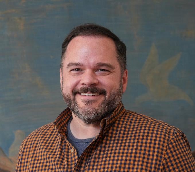 Smiling man with dark hair and a beard