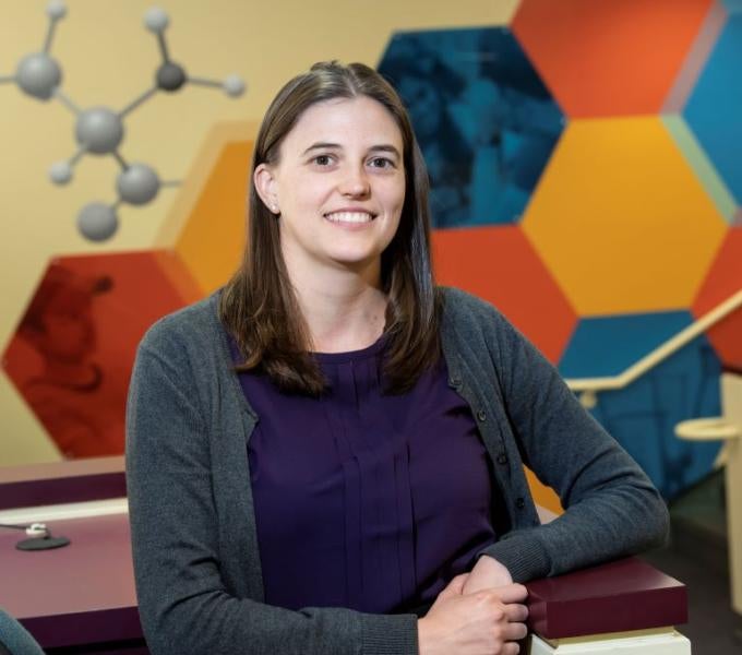 Mary Napoli stands in front of a colorful wall