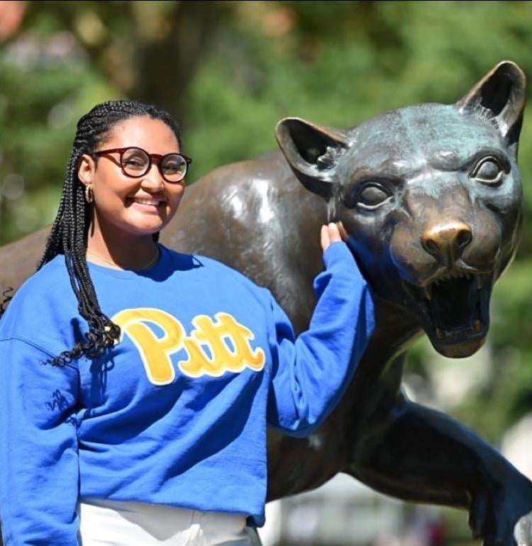 Selam Mekbeb-Gillett poses next to a panther statue on campus